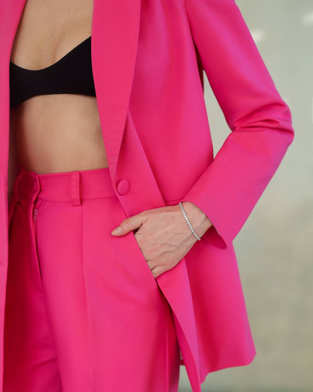 Person wearing a bright pink suit with a blurred background