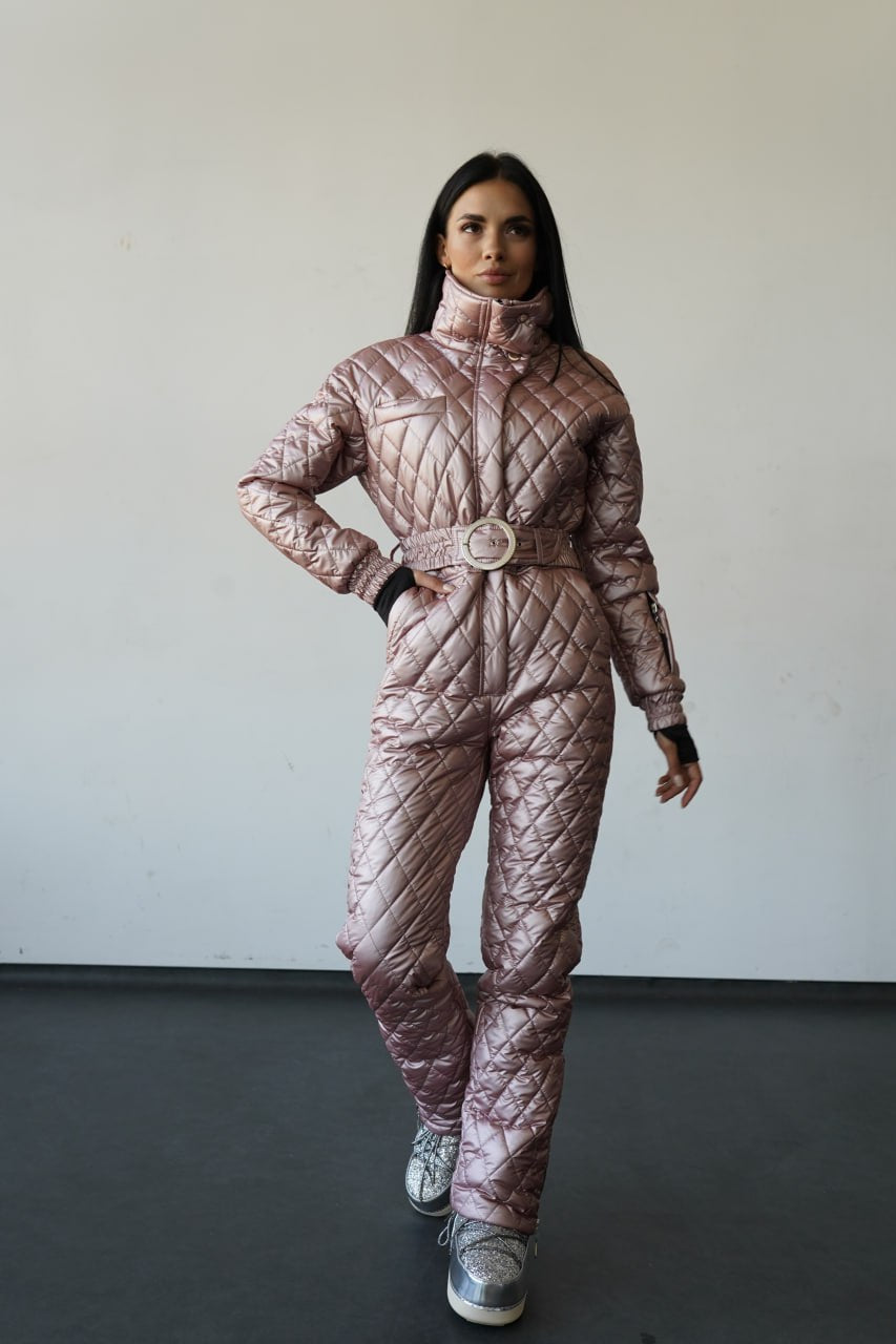 Person wearing a quilted pink snowsuit against a plain background