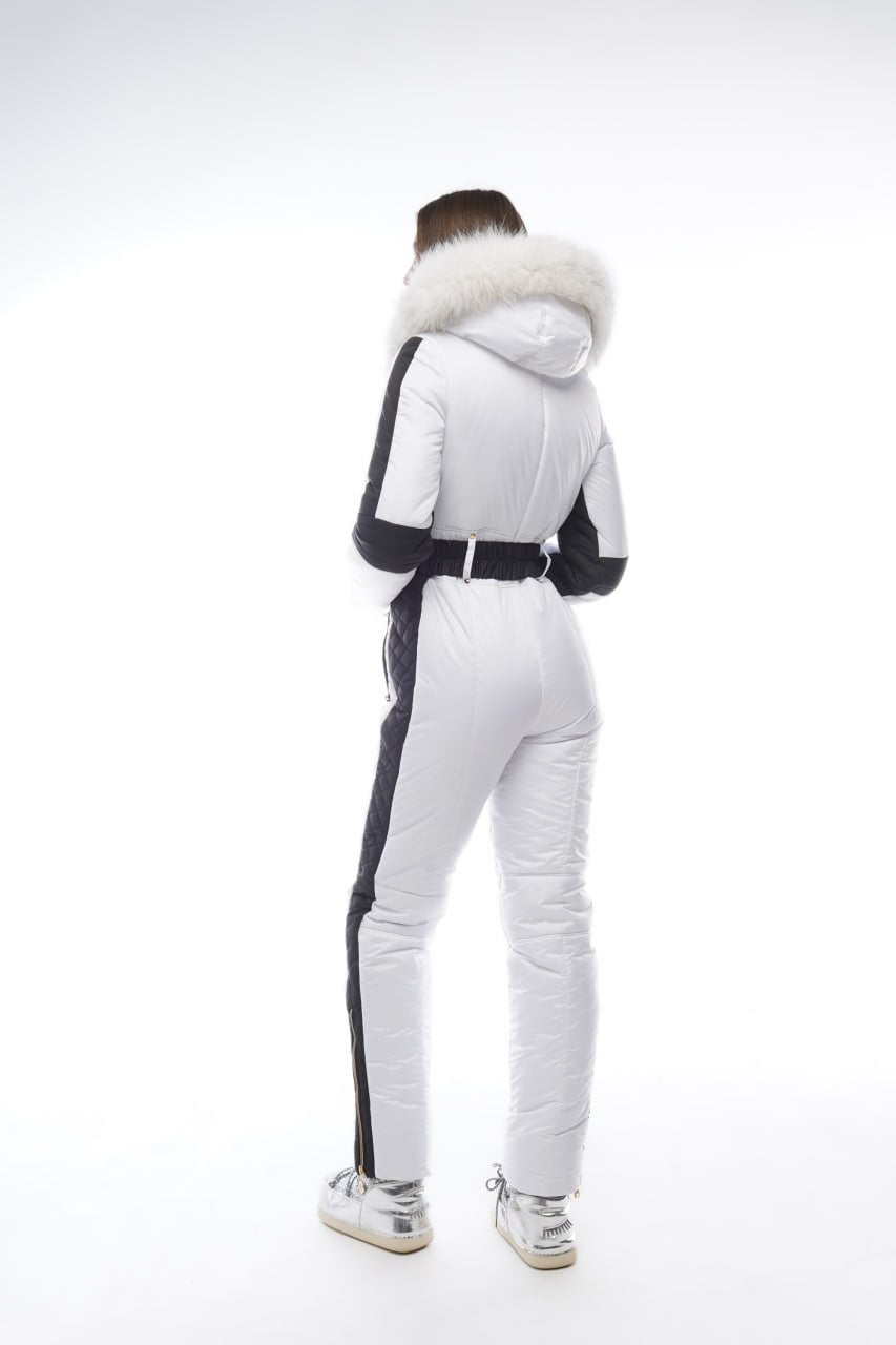 Person wearing a white and black outfit with fur-lined hood on a white background