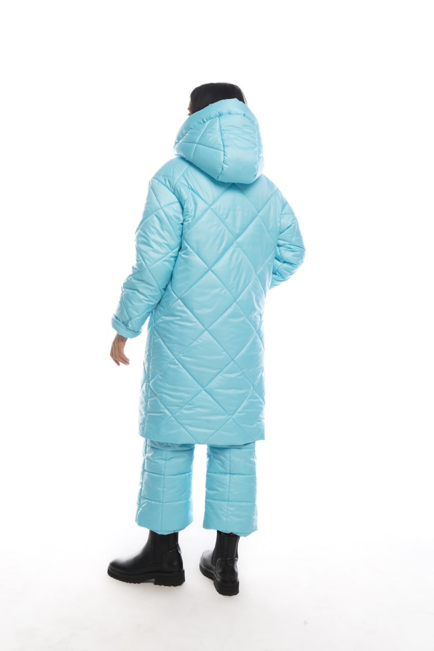 Person wearing a light blue quilted snowsuit on a white background