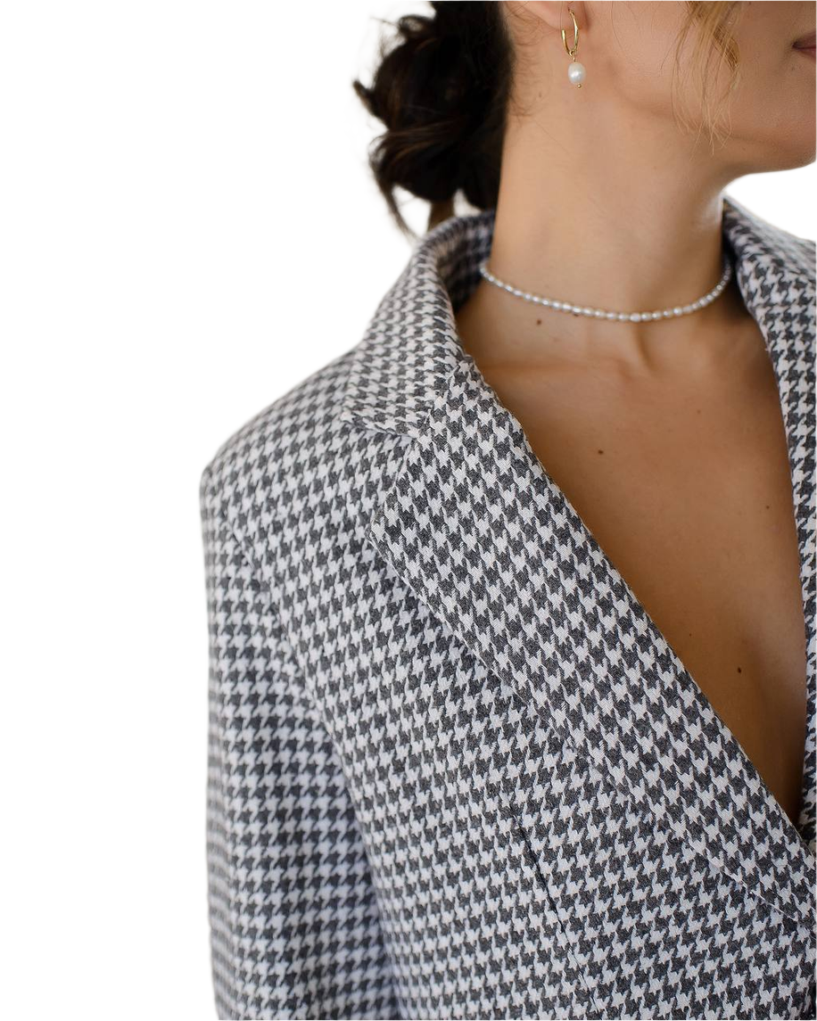 Houndstooth patterned blazer worn by a person on a white background
