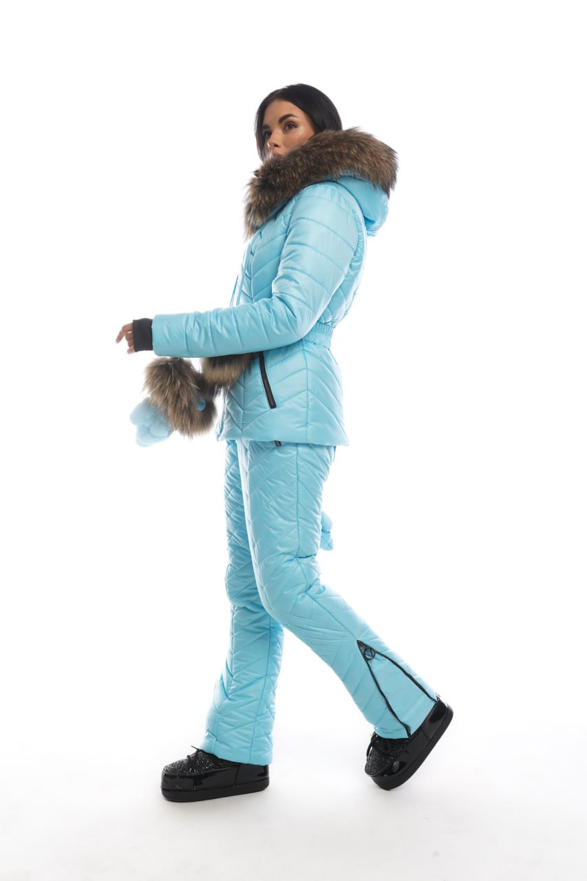 Person wearing a light blue winter suit with fur trim on a white background