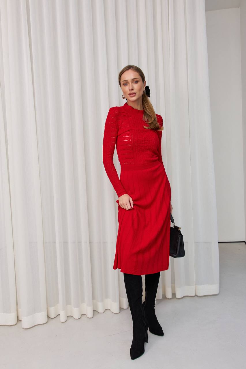 Woman in a red dress standing in front of white curtains