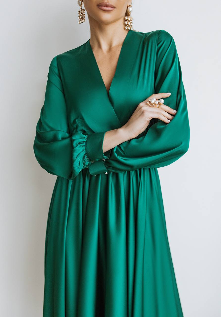 Green dress worn by a person on a plain background