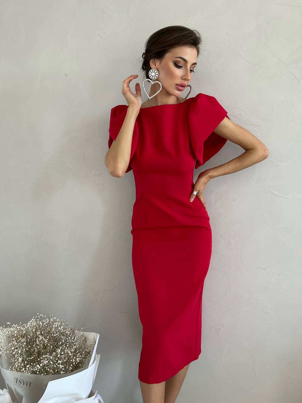 Woman wearing a red dress against a plain background