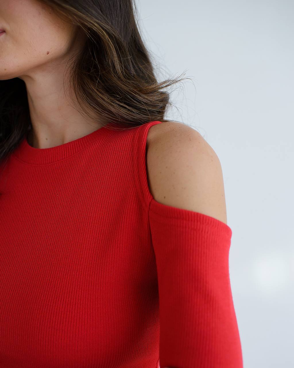 Red top worn by a person on a white background