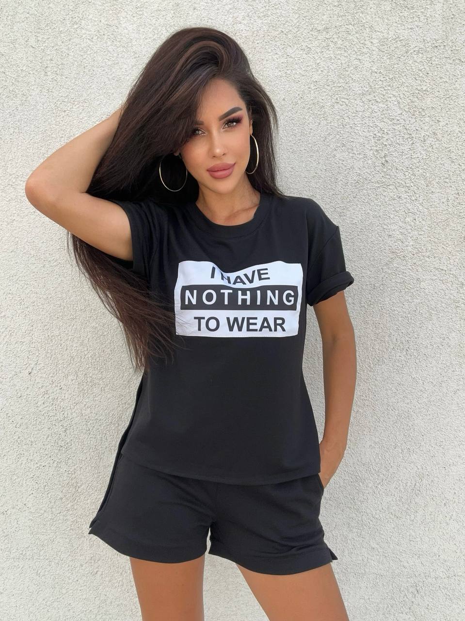 Woman wearing a black t-shirt with 'I Have Nothing to Wear' text against a light gray background