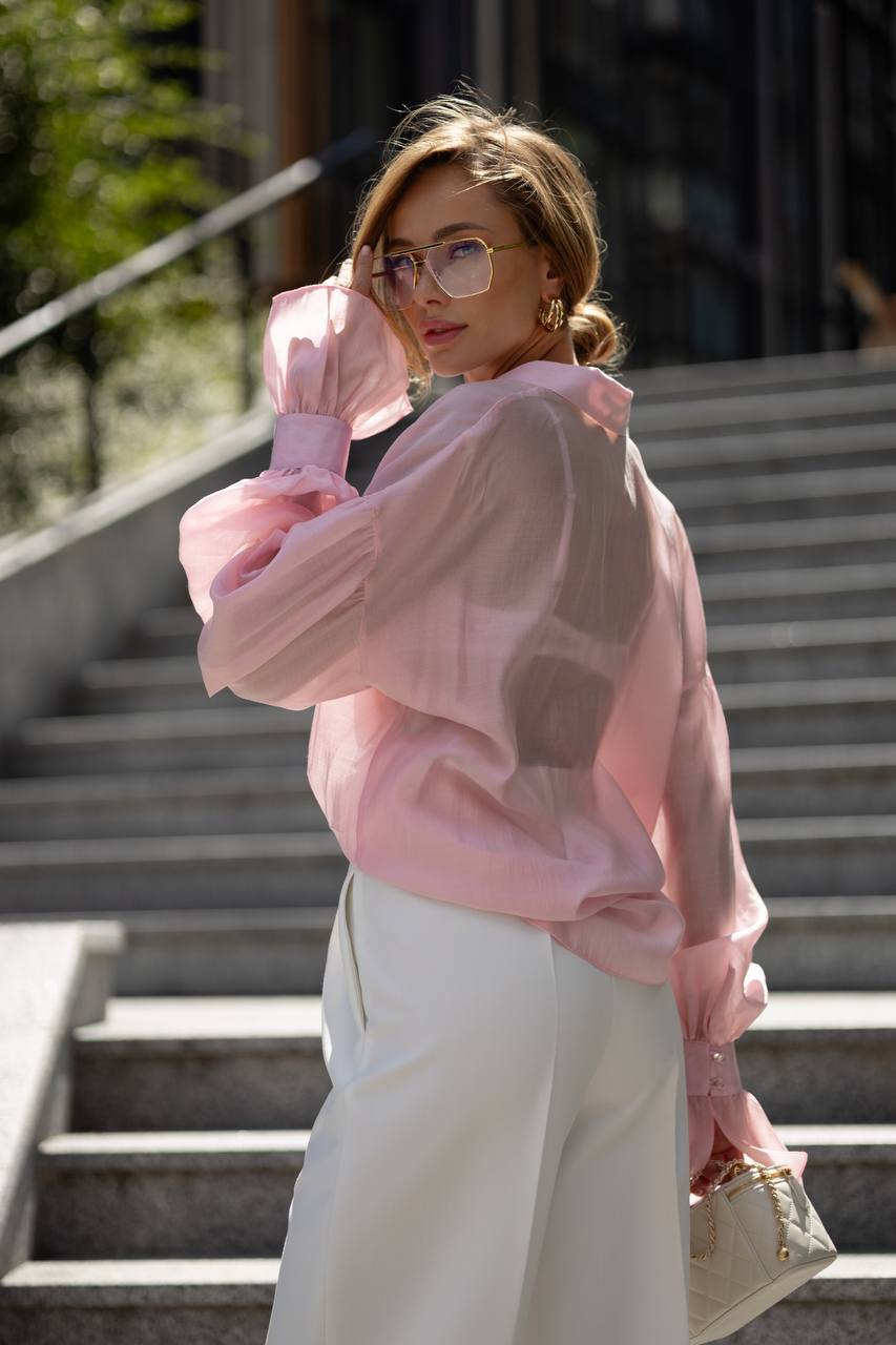 Woman wearing a pink outfit standing on steps outdoors