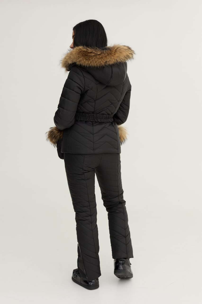 Person wearing a black winter coat with fur trim on a white background