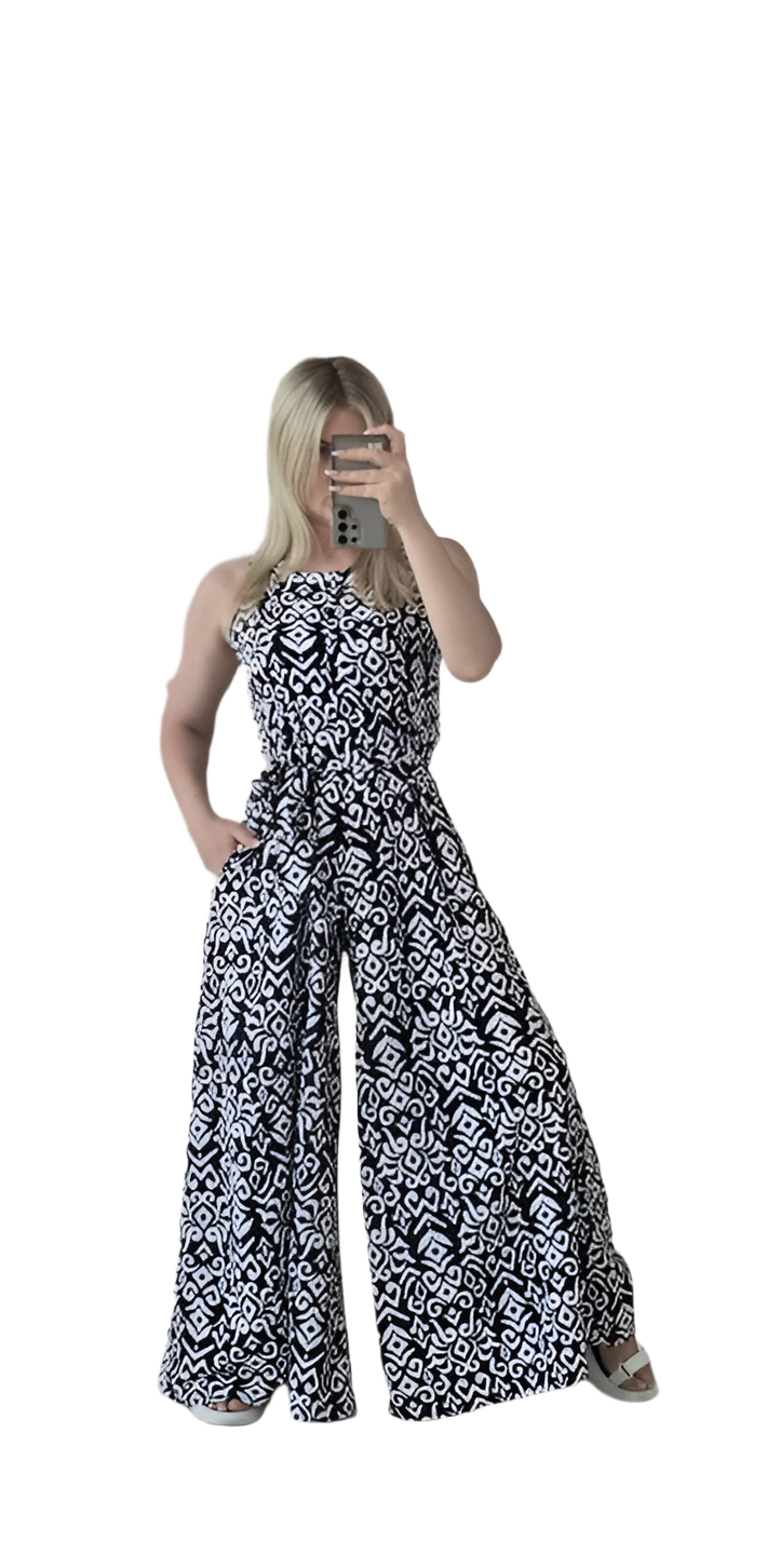 Woman wearing a black and white patterned strapless jumpsuit on a white background