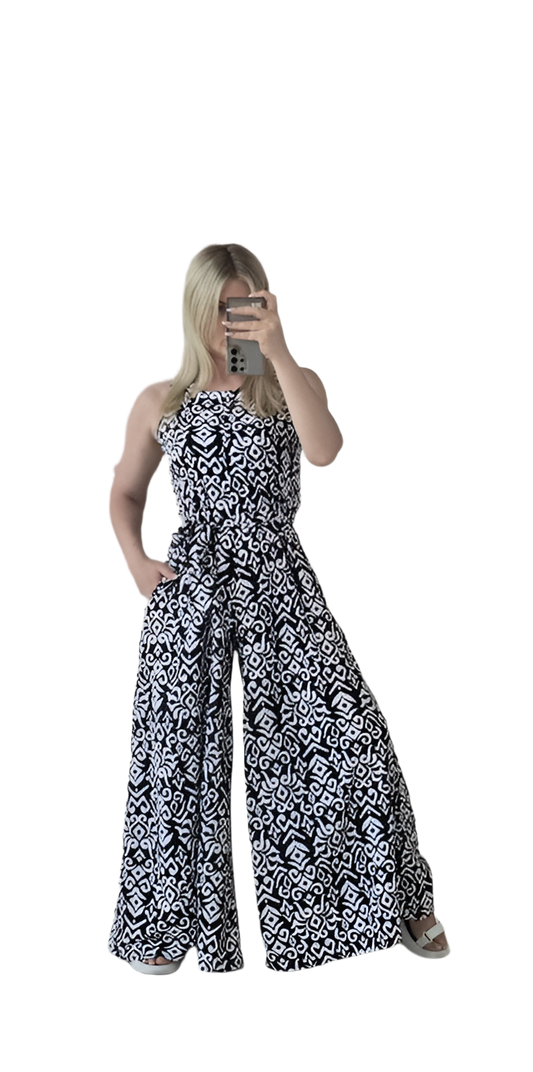 Woman wearing a black and white patterned strapless jumpsuit on a white background