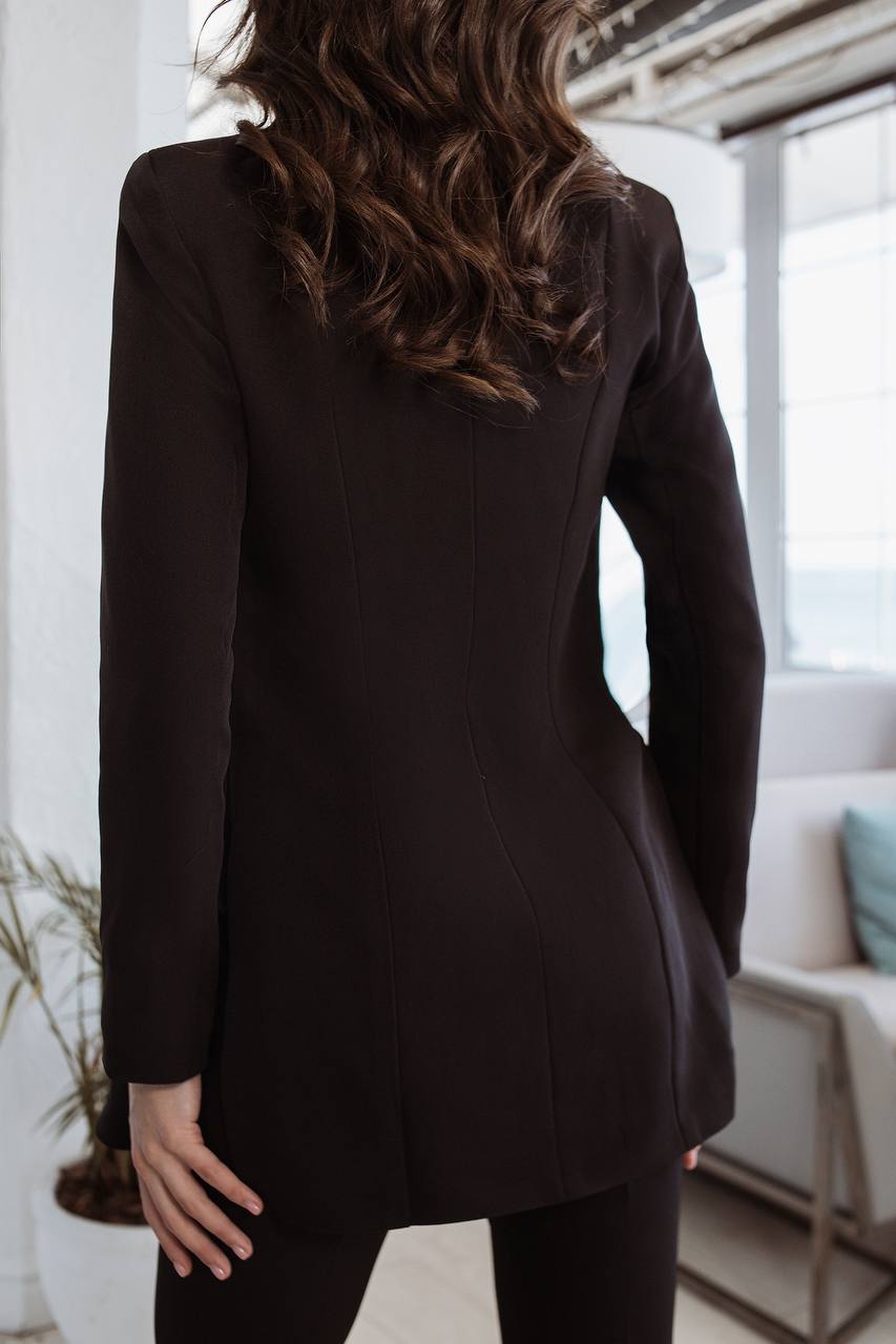 Person wearing a black blazer in an indoor setting