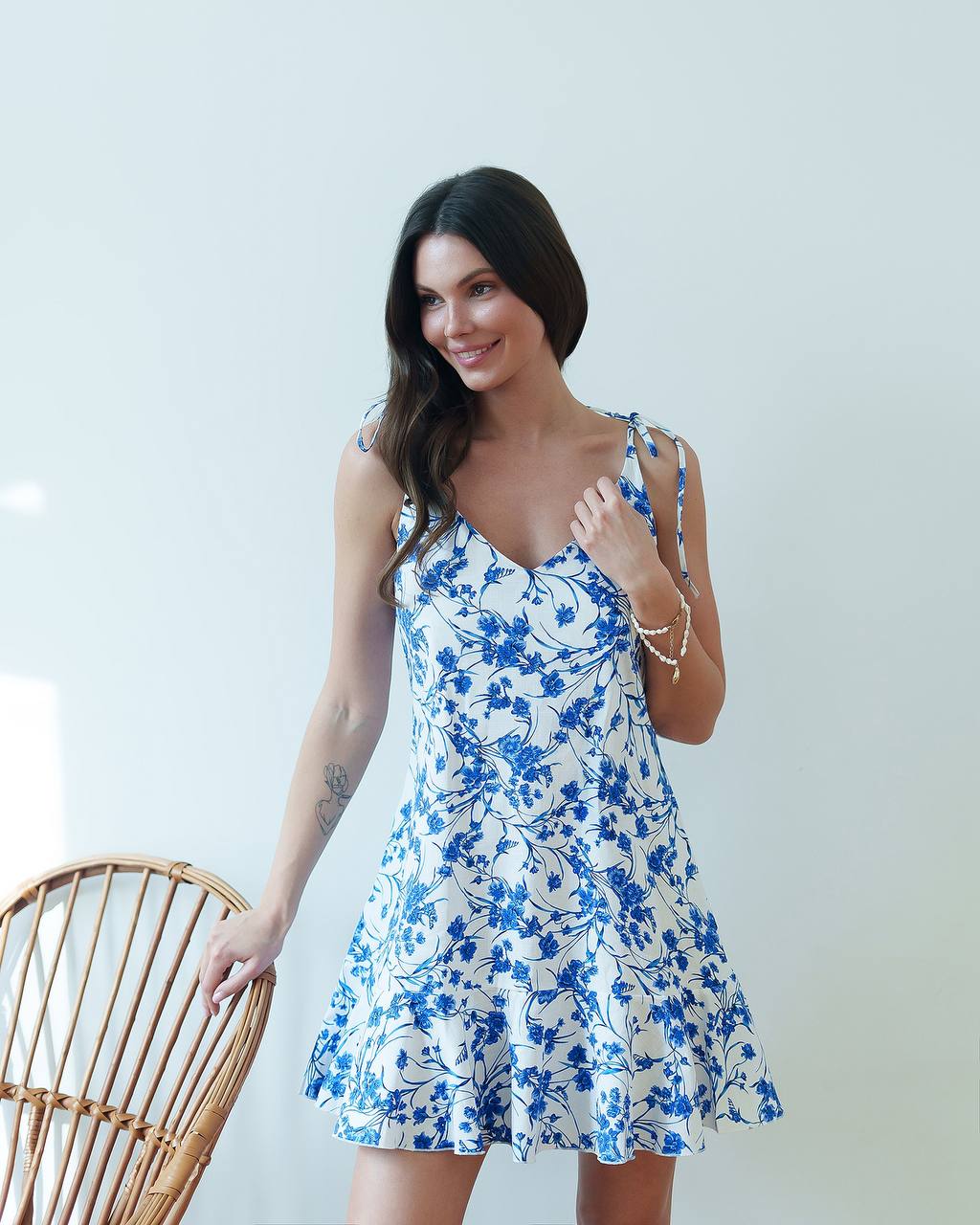 Woman wearing a blue floral dress against a white background