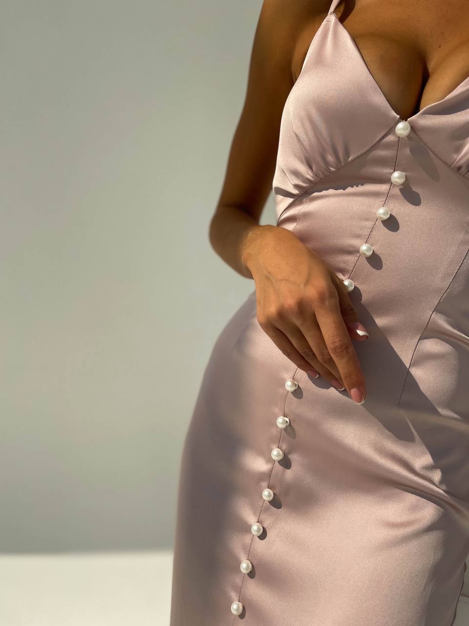 Light pink dress with pearl buttons on a neutral background