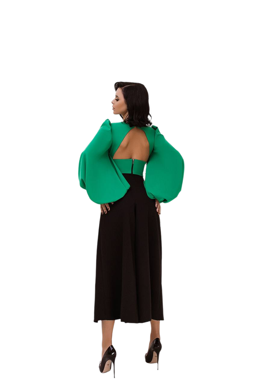 Woman wearing a green open-back top and black skirt on a white background
