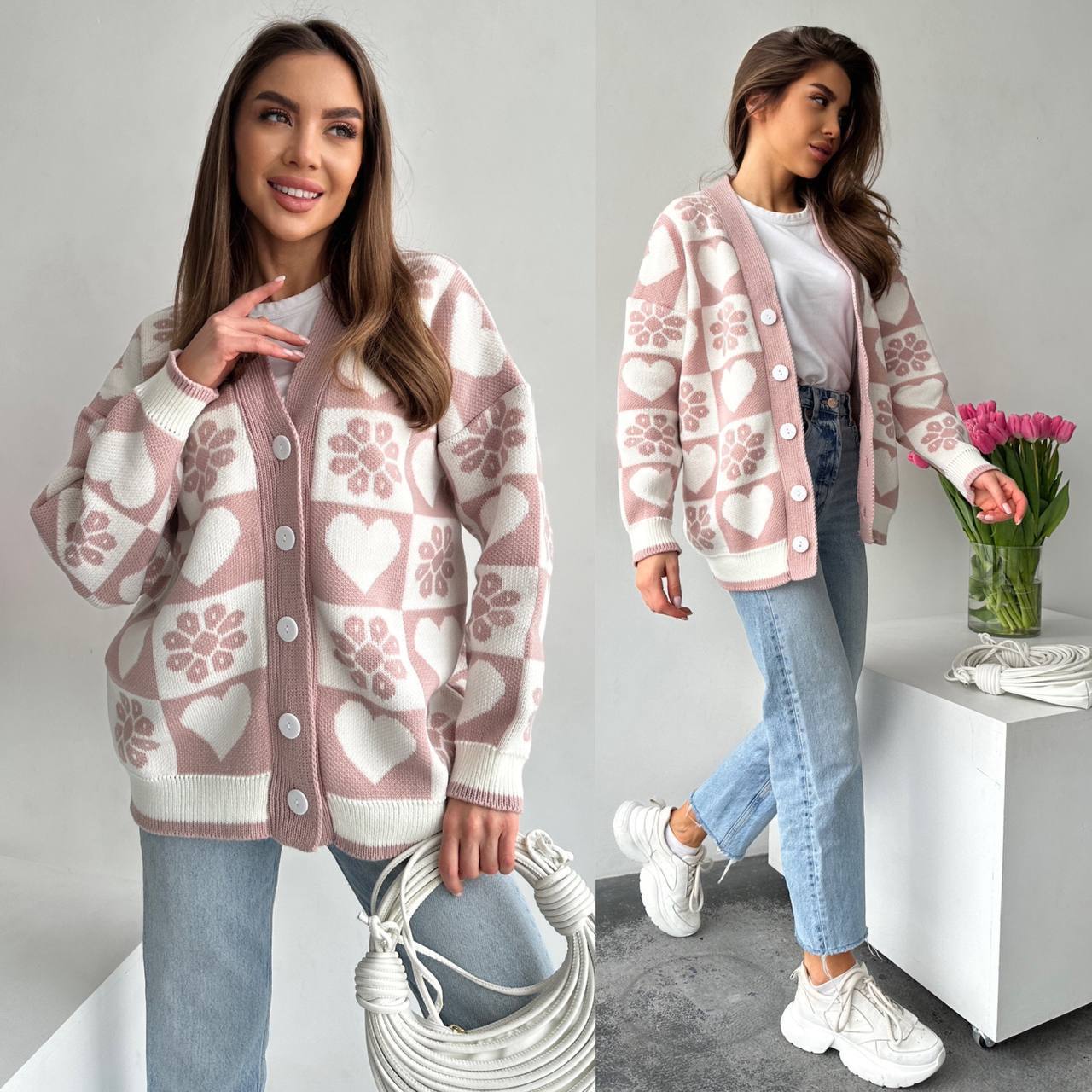 Woman wearing a pink and white patterned cardigan in a minimalistic room.