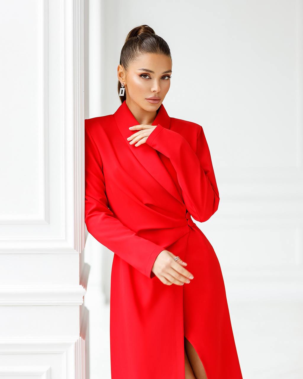 Woman wearing a red coat against a white background