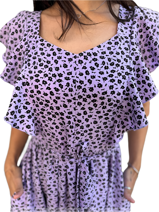 Purple dress with black floral pattern worn by a person