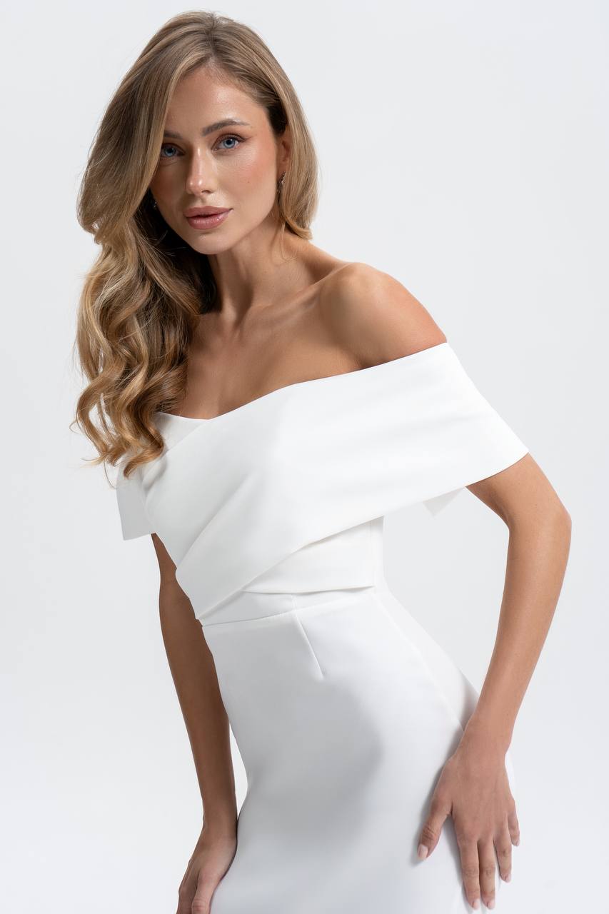 Woman wearing a white off-shoulder dress against a white background