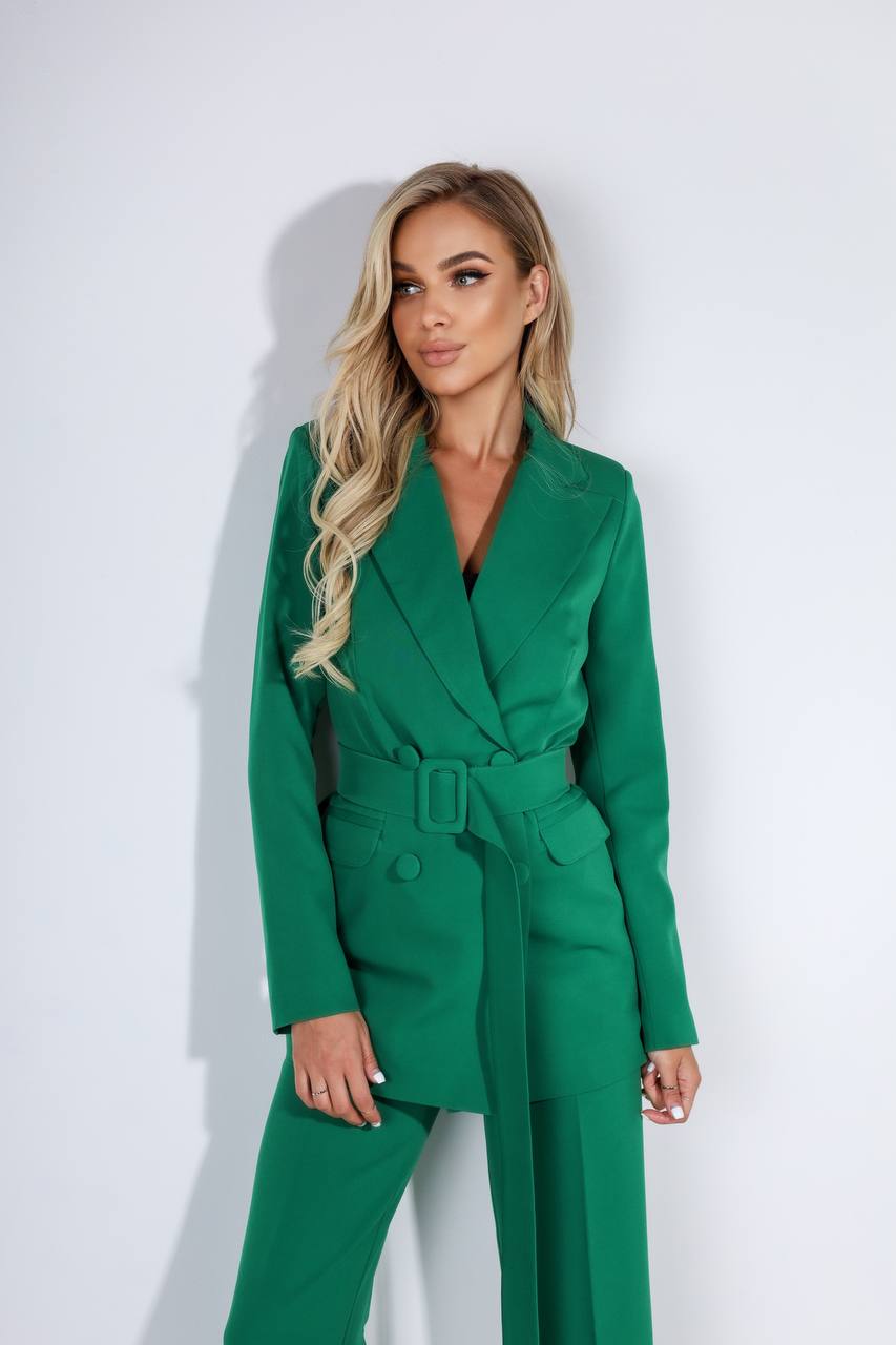 Woman wearing a green suit against a white background