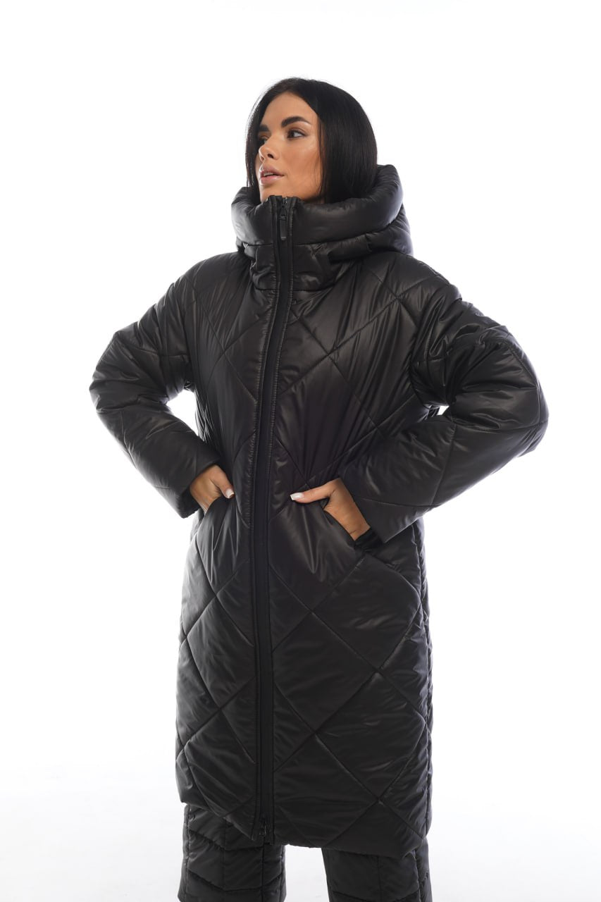 Person wearing a black quilted jacket on a white background