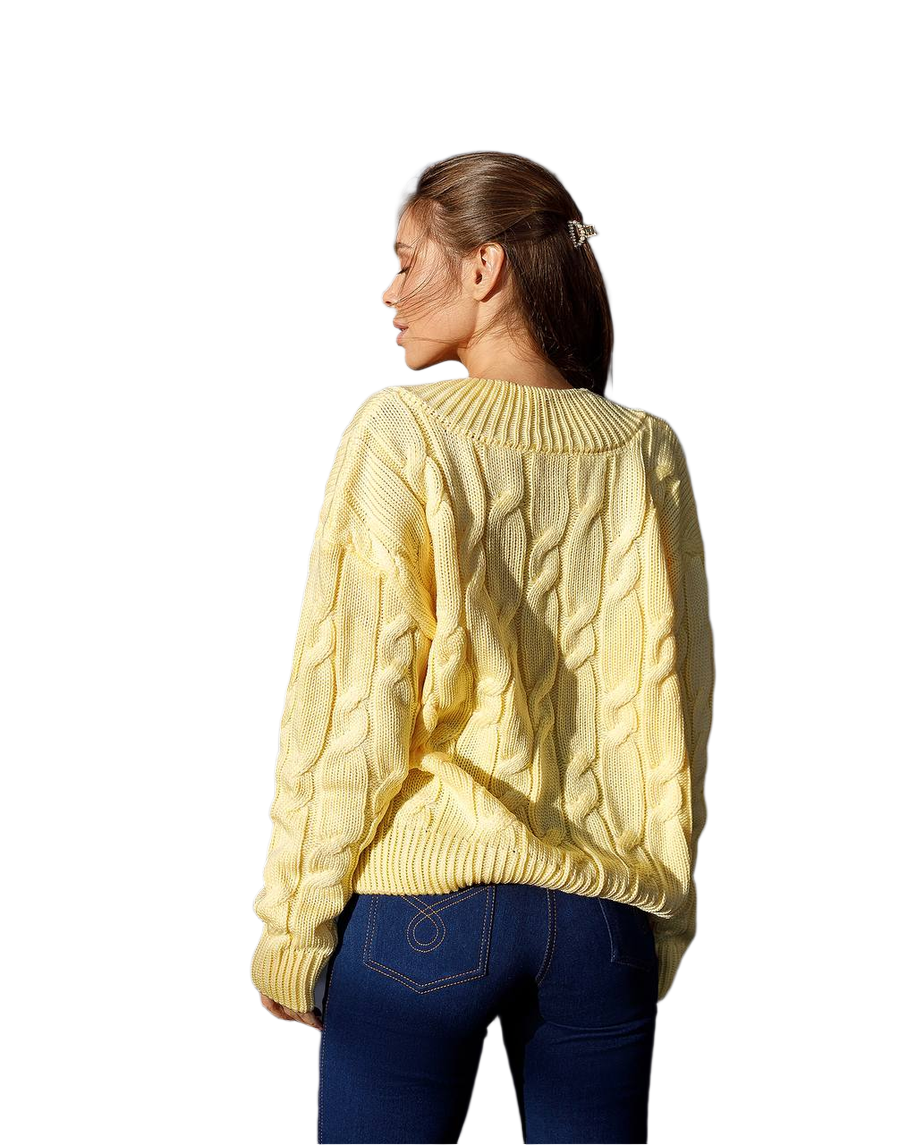 Woman wearing a yellow cable knit sweater on a white background