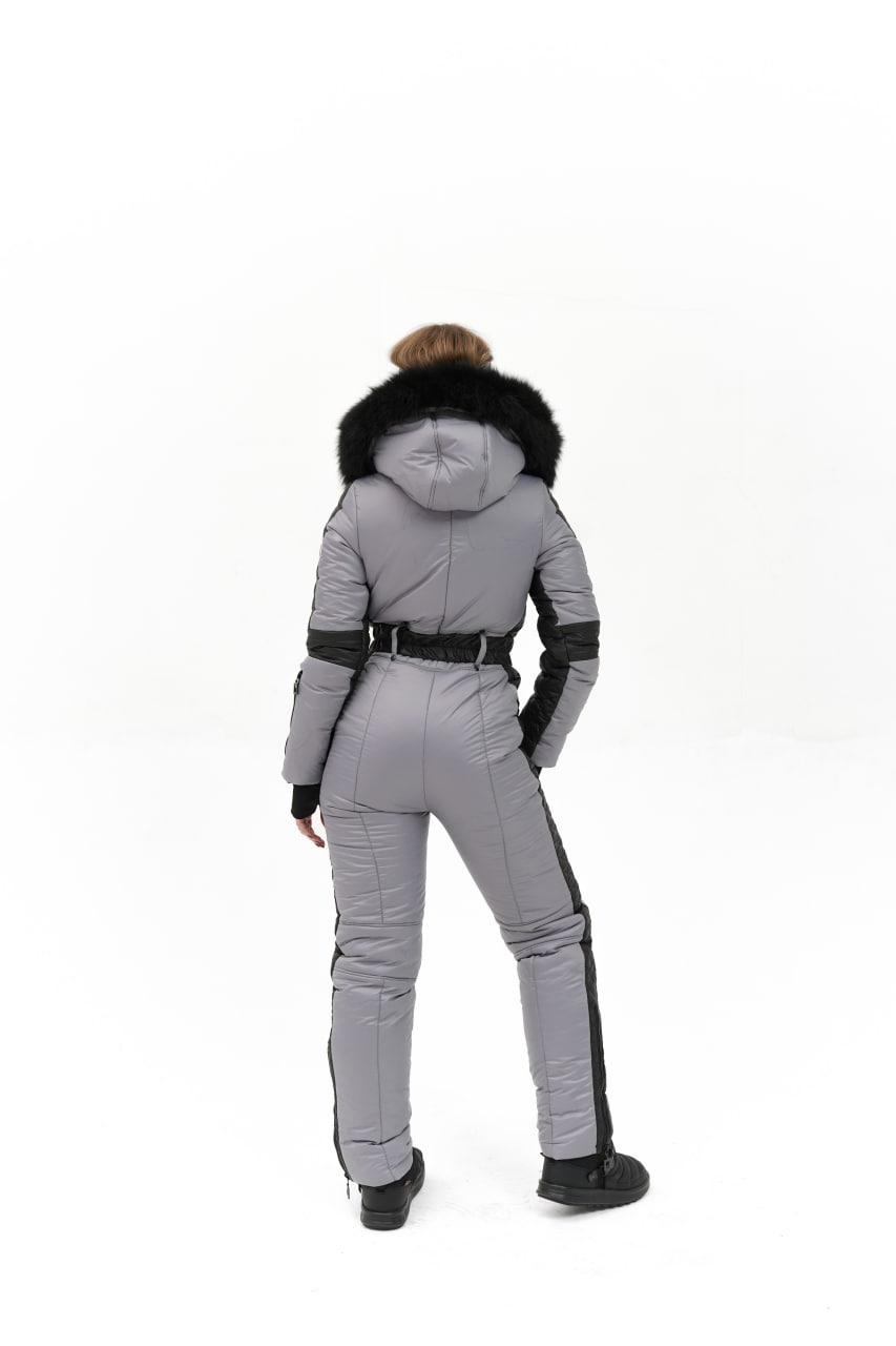 Person wearing a gray and black snowsuit with a hood on a white background