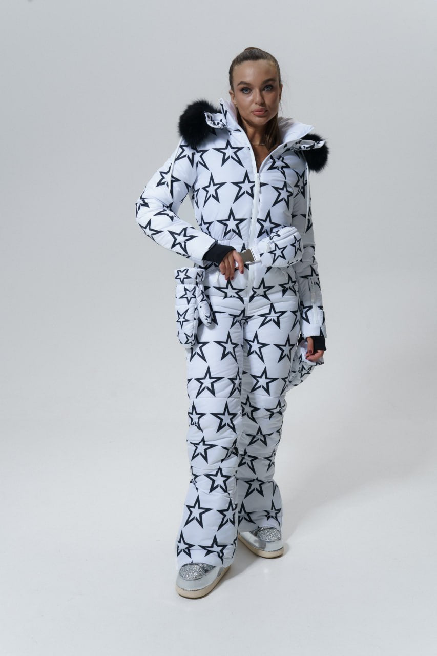 Person wearing a white snowsuit with black star patterns on a white background