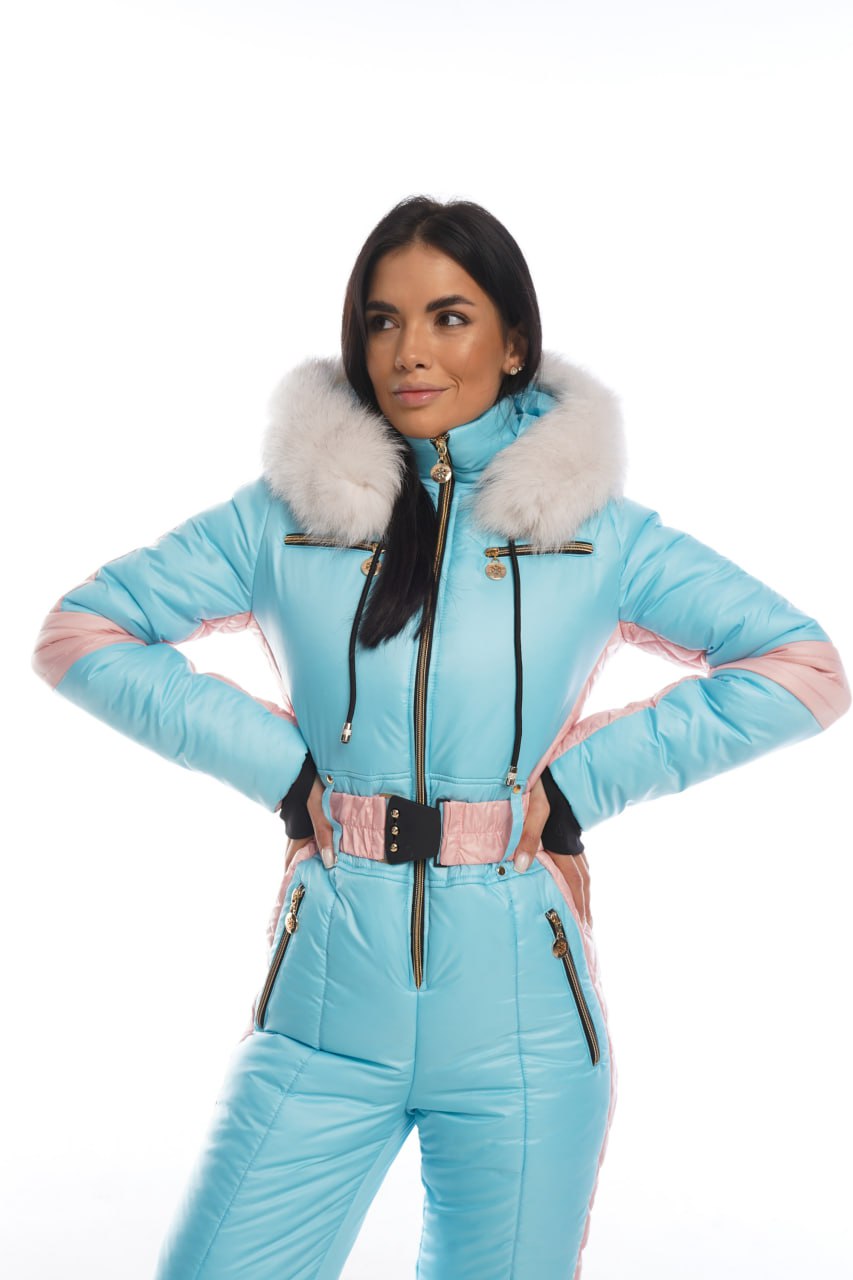 Woman wearing a light blue ski suit with white fur trim on a white background