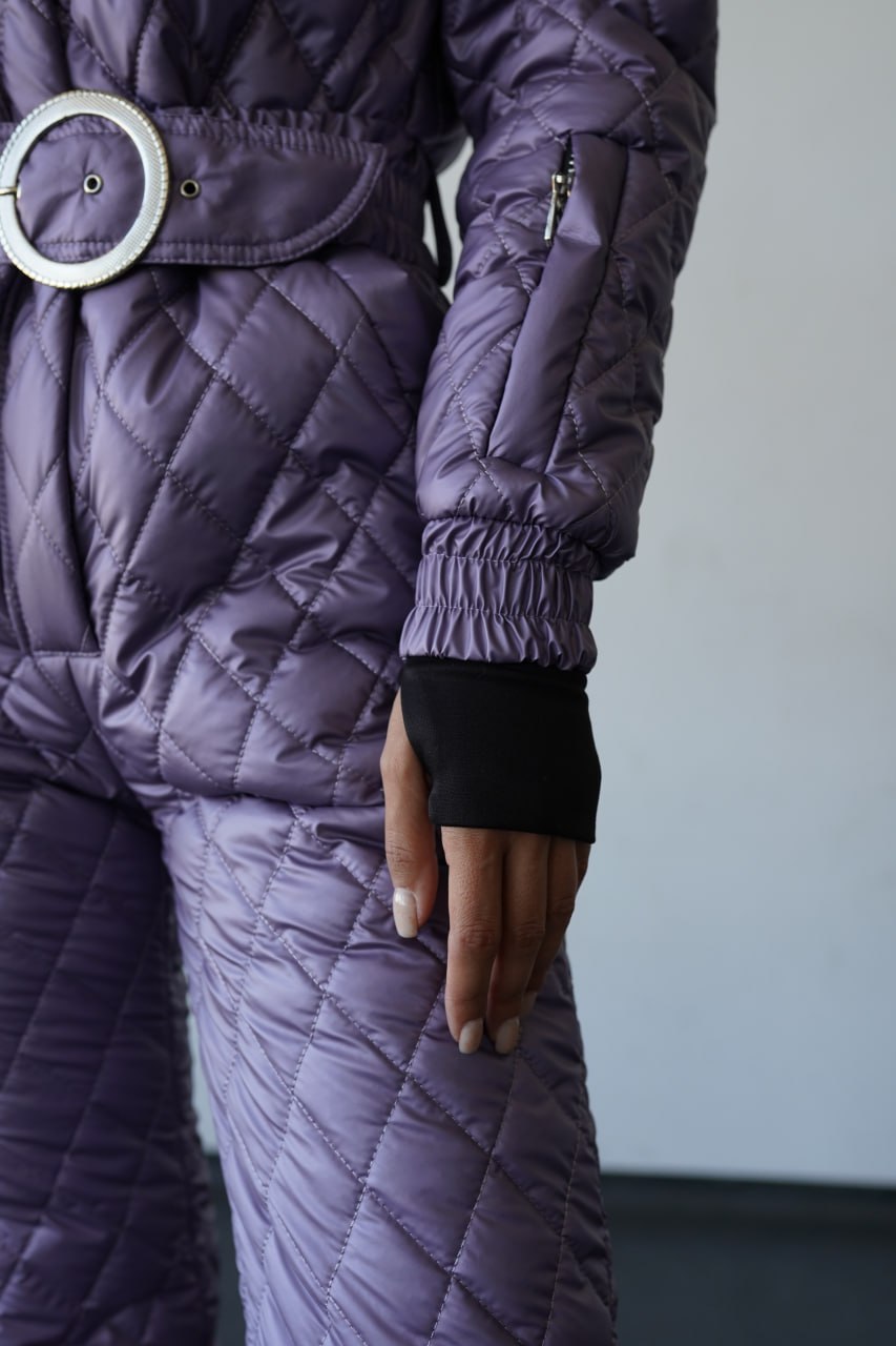 Person wearing a quilted purple coat with a white background