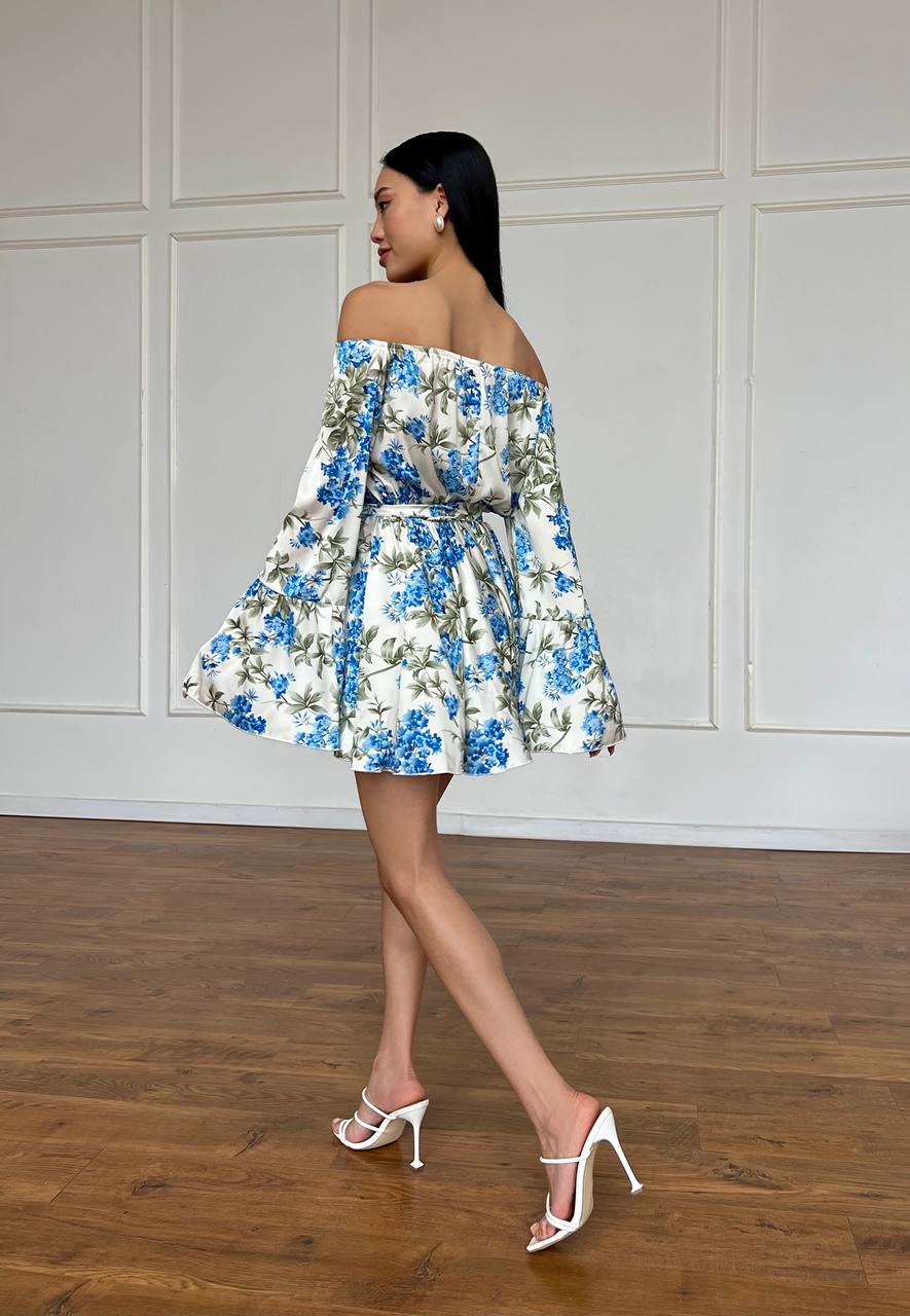 Woman wearing a floral off-shoulder dress in a minimalistic setting