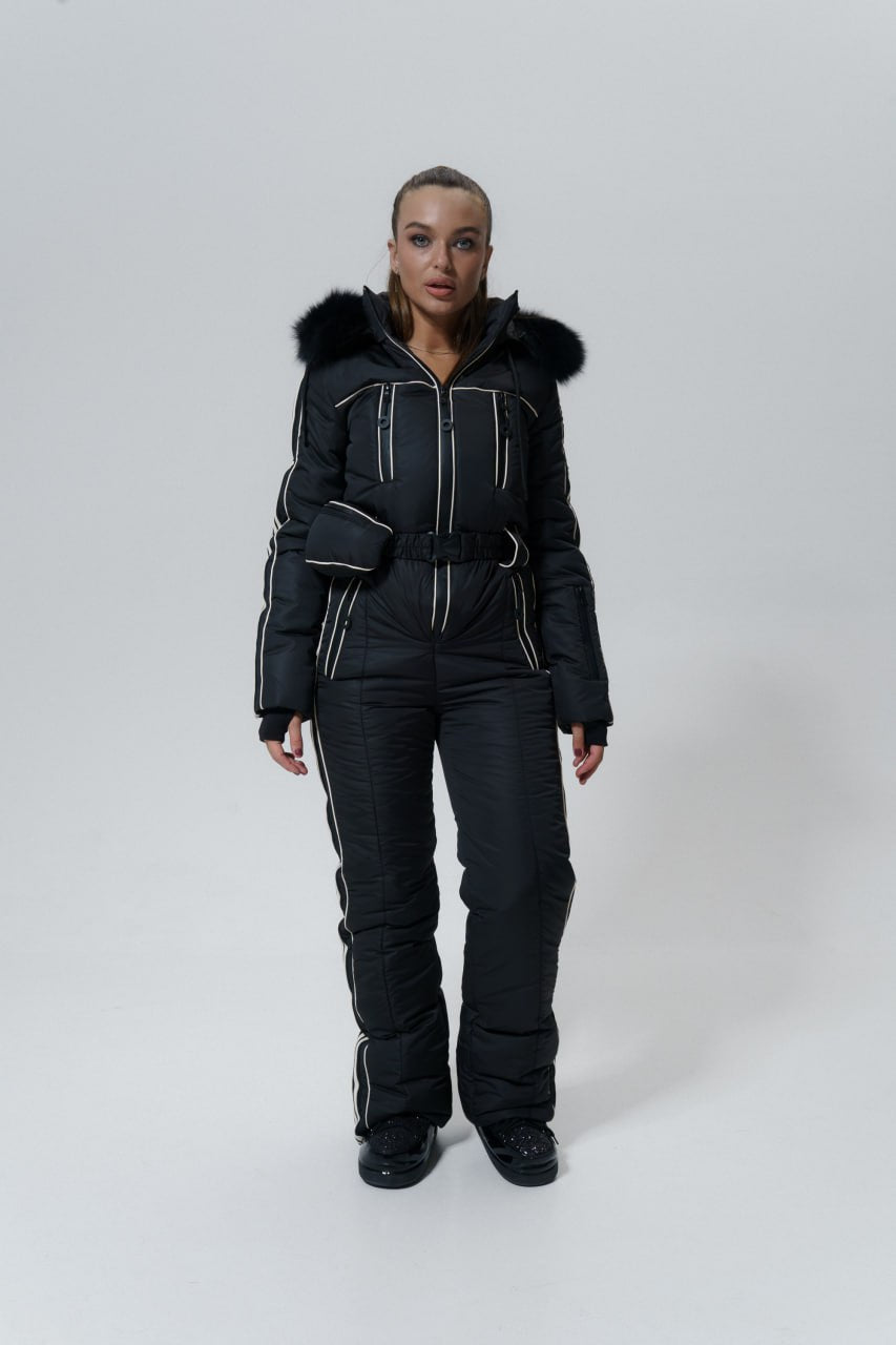Person wearing a black snowsuit with fur hood on a white background