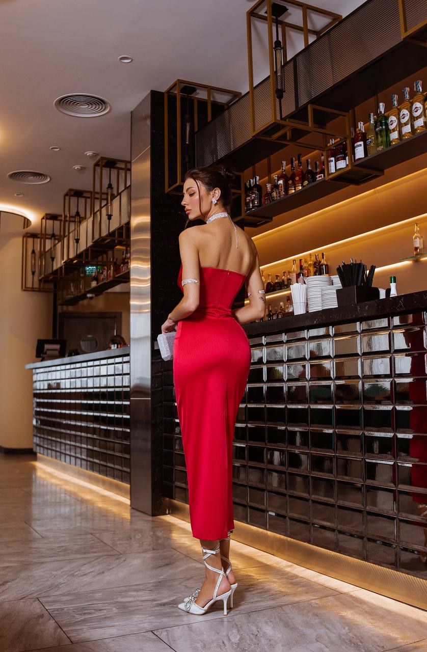 Woman in a red dress standing in a bar setting