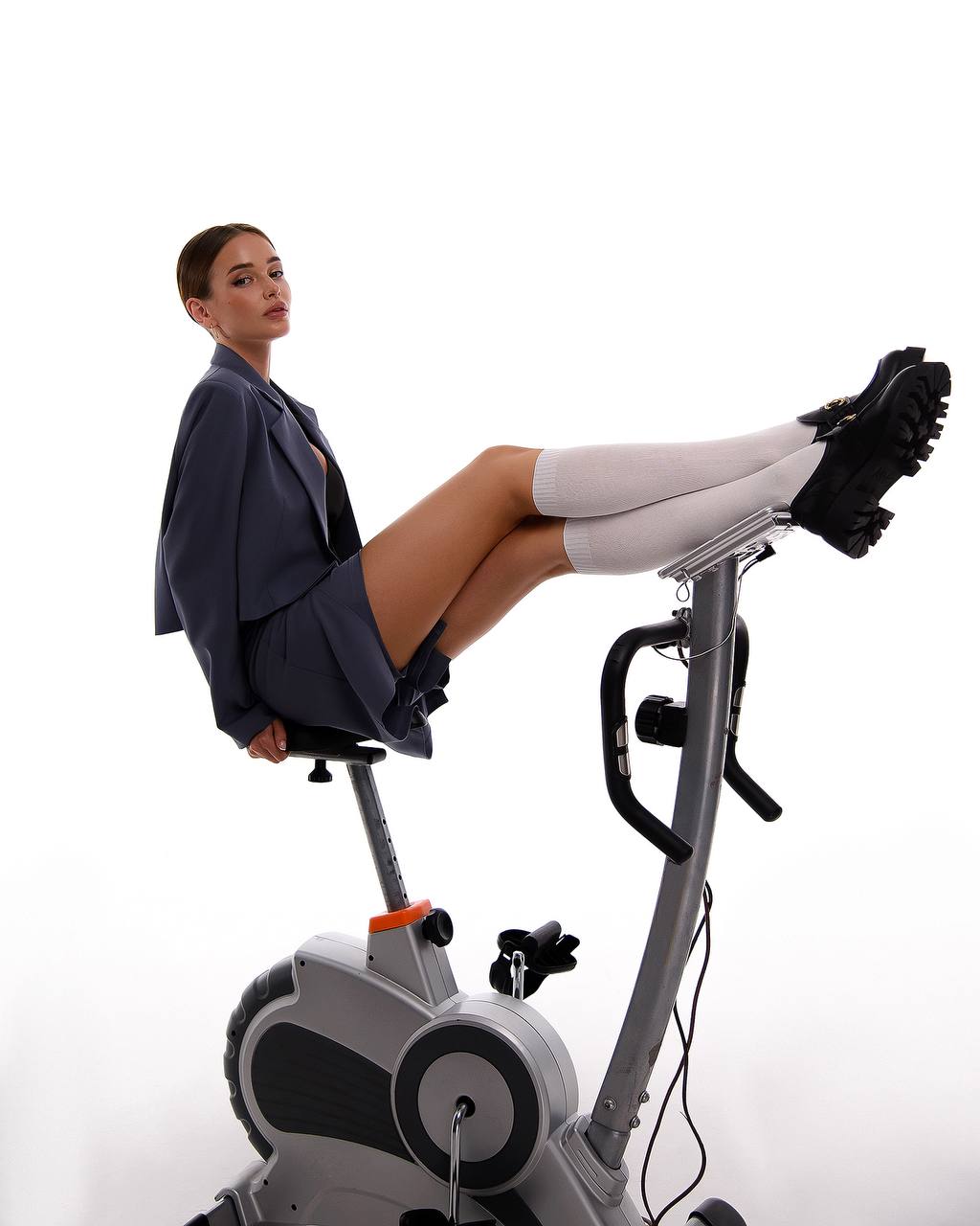 Woman exercising on a stationary bike against a white background