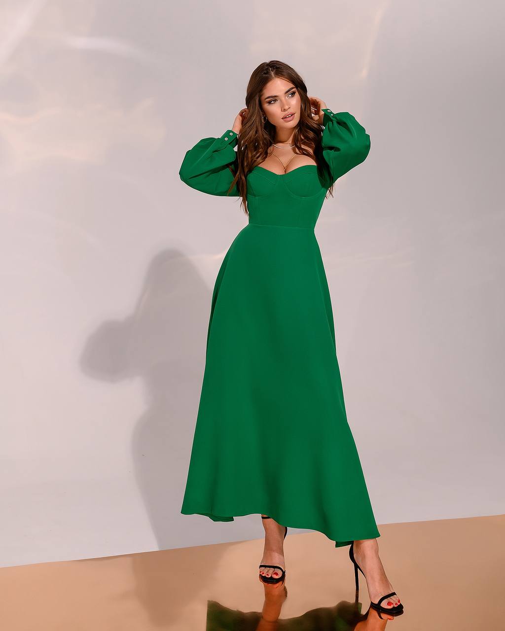 Woman wearing a green dress against a plain background