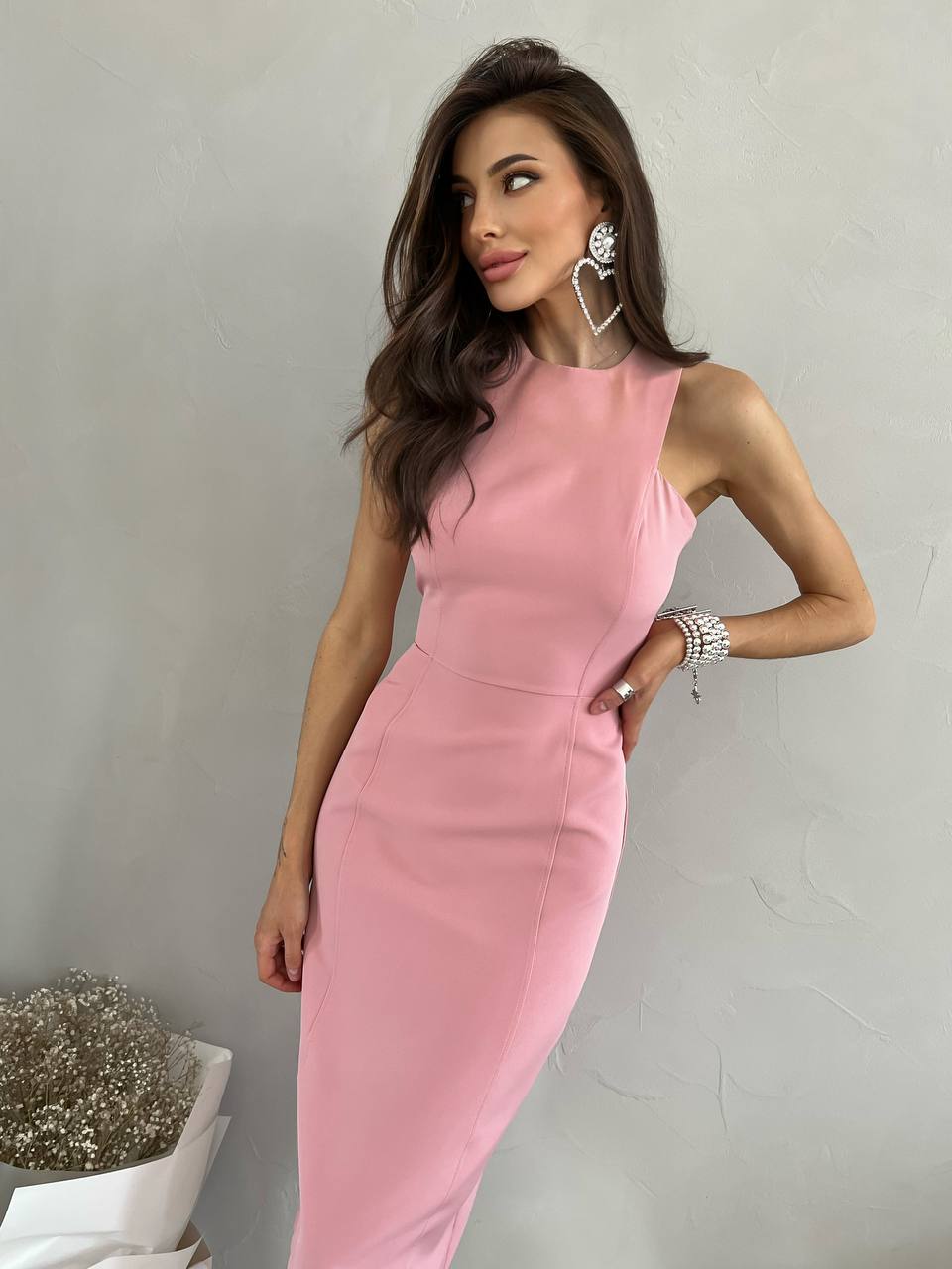 Woman wearing a pink dress against a plain background
