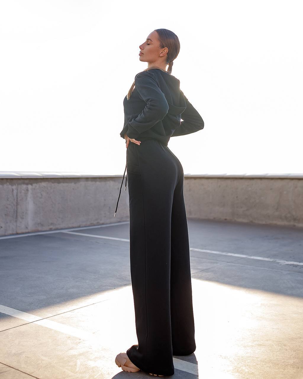 Person wearing a long dark green dress standing on a rooftop.