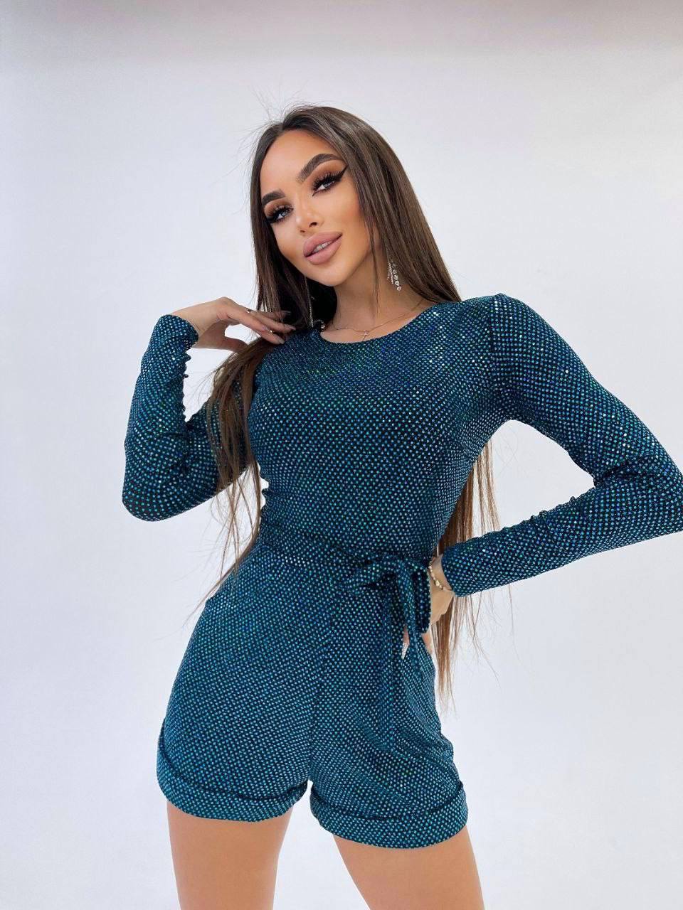 Woman wearing a teal knit outfit on a white background