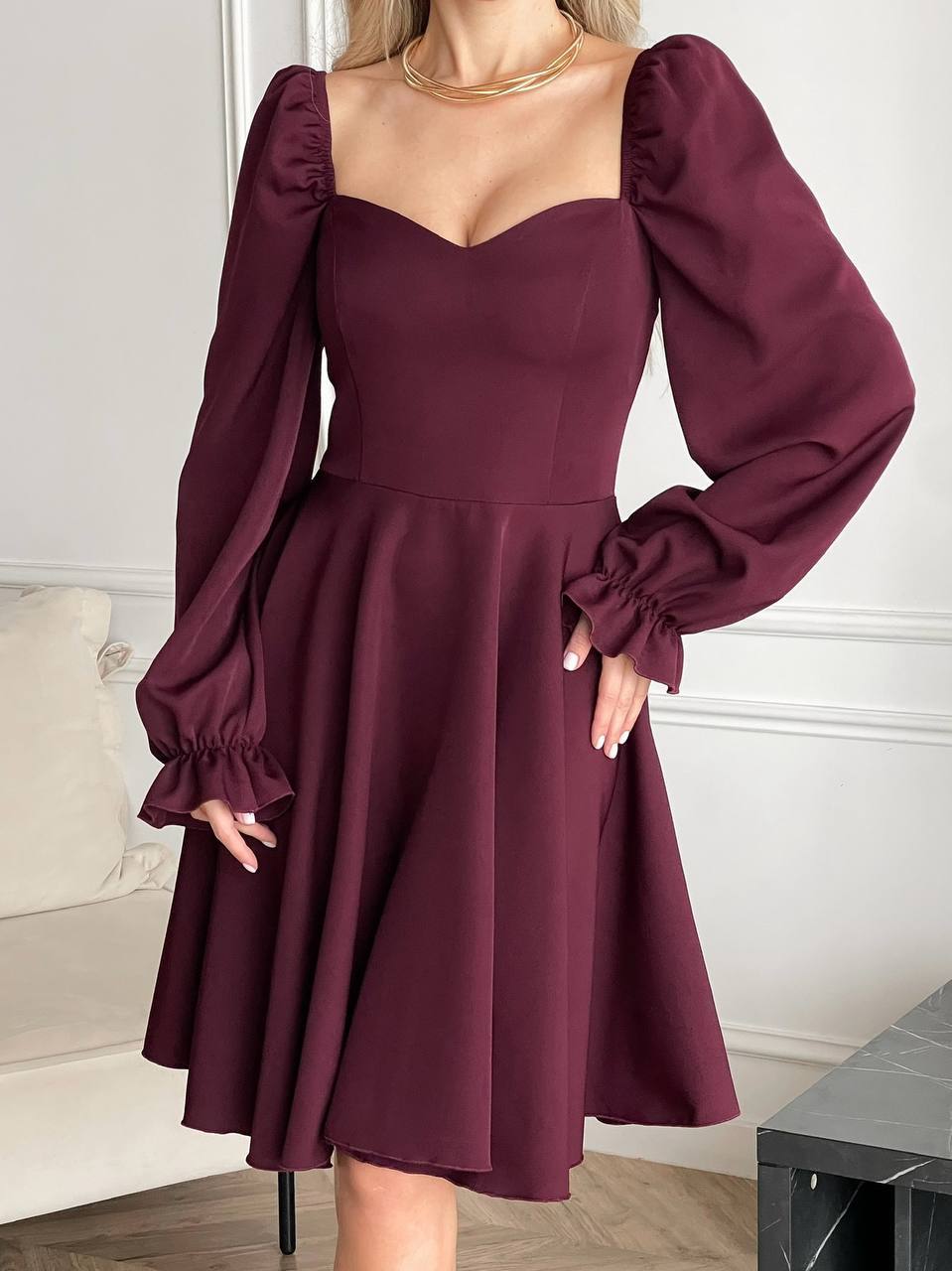 Maroon dress with puff sleeves worn by a person indoors.