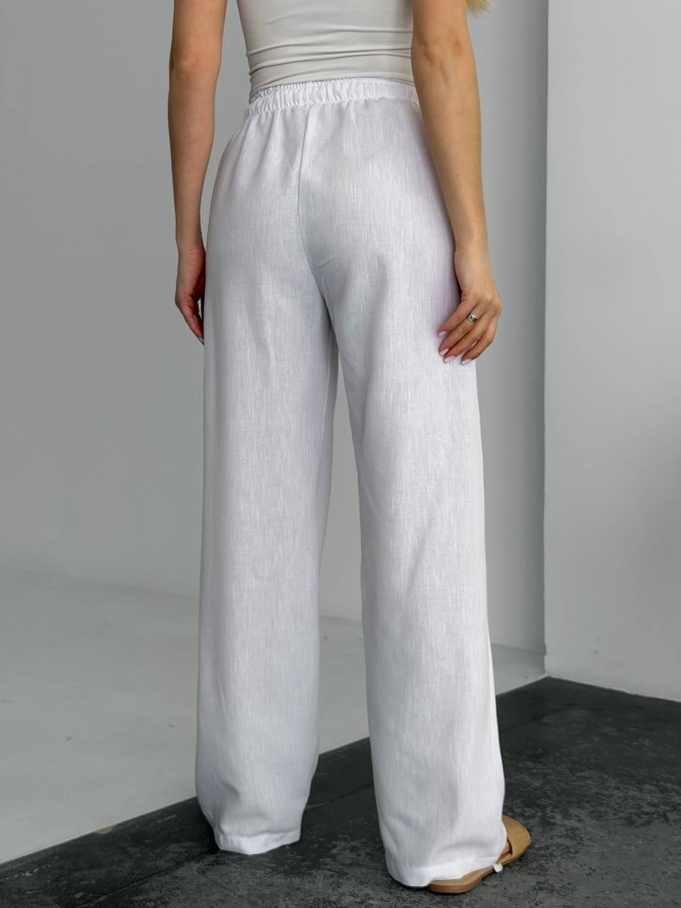 Person wearing light gray wide-leg pants against a plain background