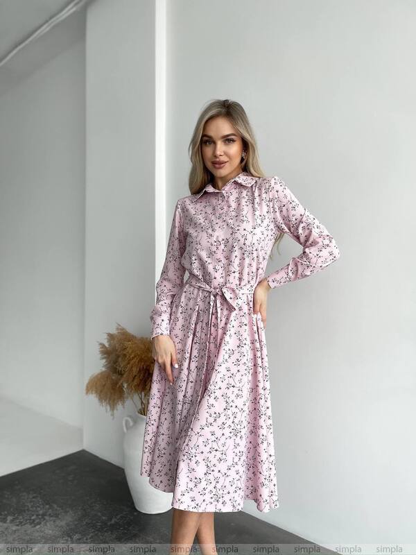 Woman wearing a pink floral dress in a minimalistic setting