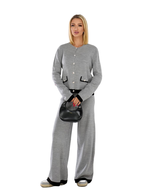 Woman wearing a gray outfit with a black handbag on a white background