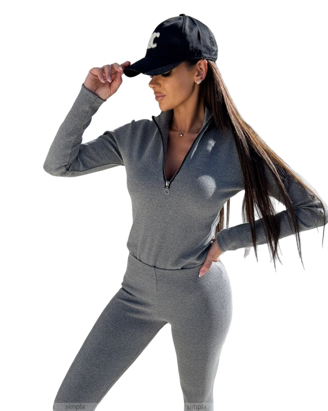 Woman wearing a gray athletic outfit and black cap on a white background