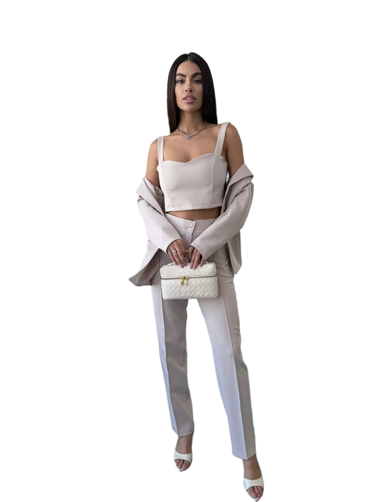 Woman in a stylish outfit with a white top and pants, holding a matching handbag on a white background.