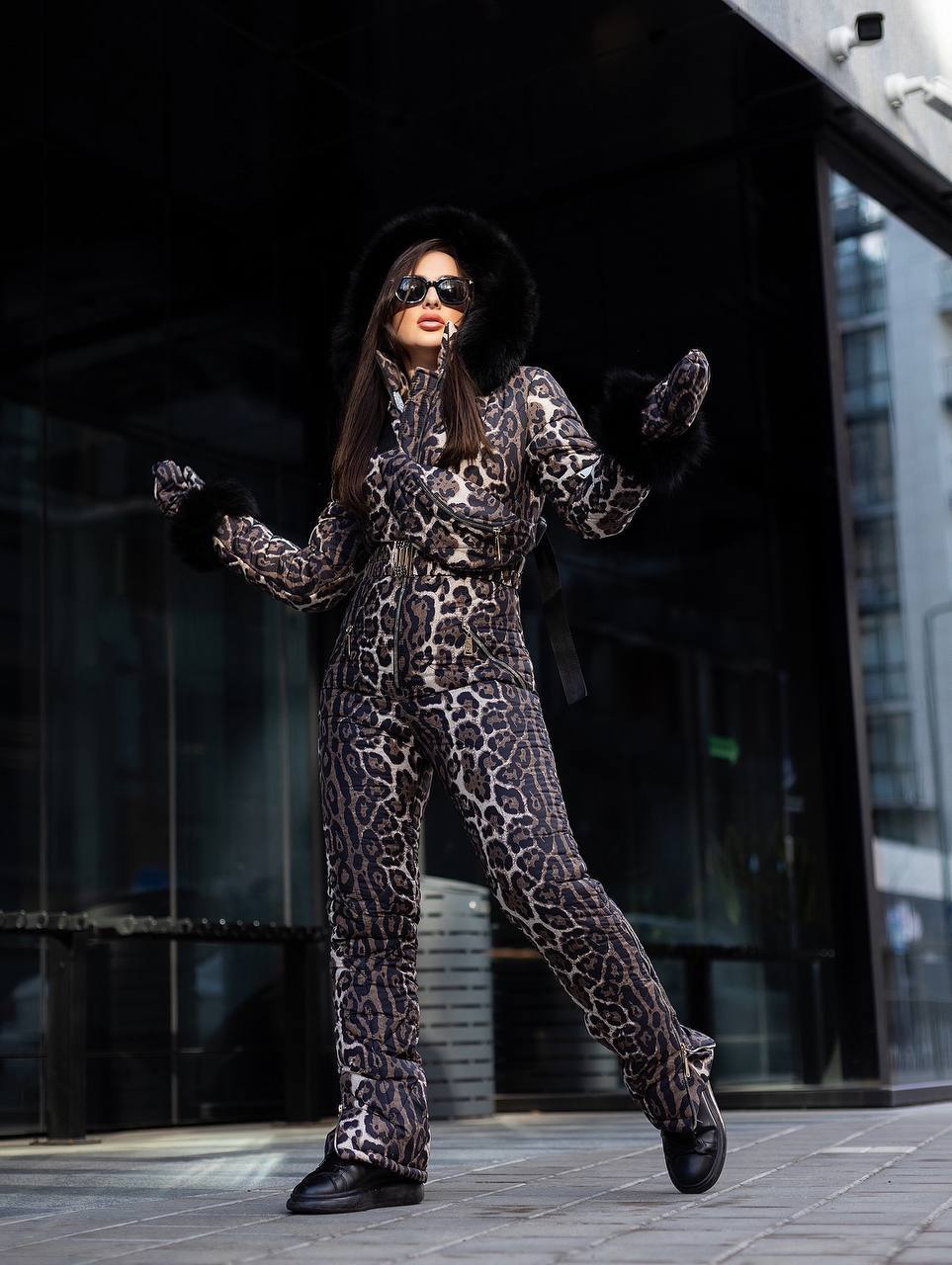 Person wearing a leopard print outfit with sunglasses and gloves in an urban setting