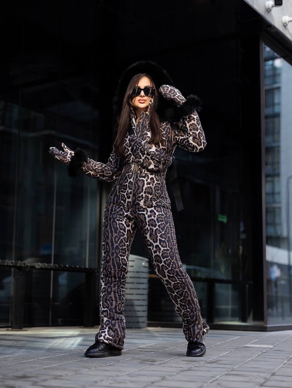Person wearing a leopard print outfit with fur-trimmed gloves in an urban setting