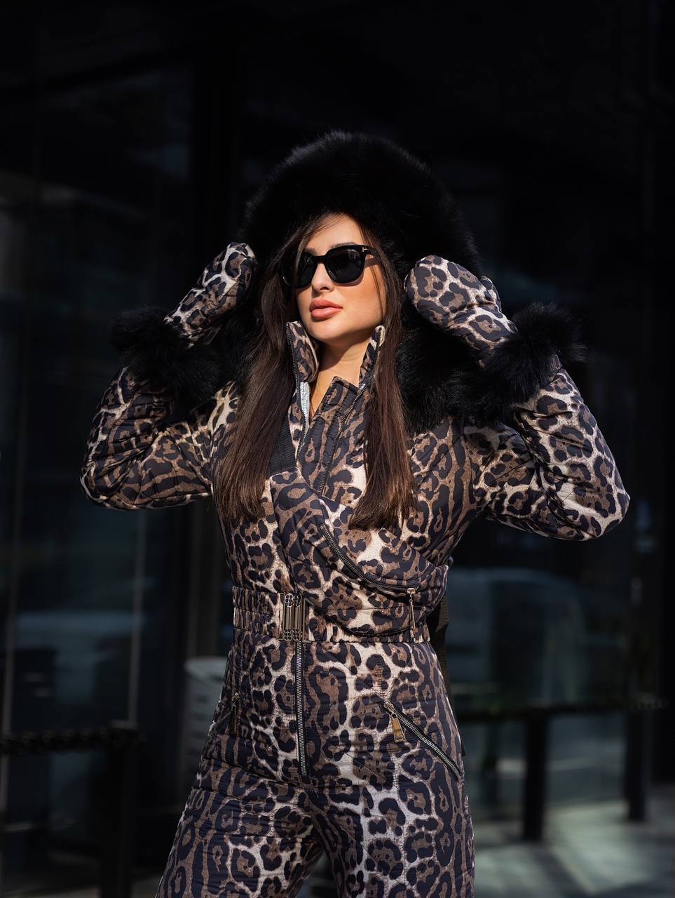 Woman wearing a leopard print outfit with fur hat and sunglasses in a dark setting