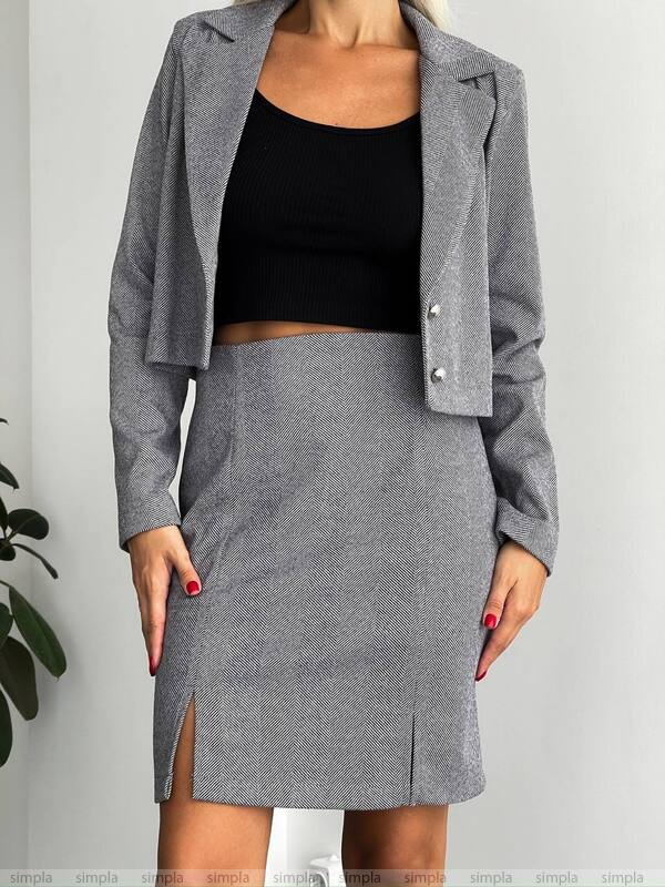 Gray blazer and skirt set with black top on a plain background