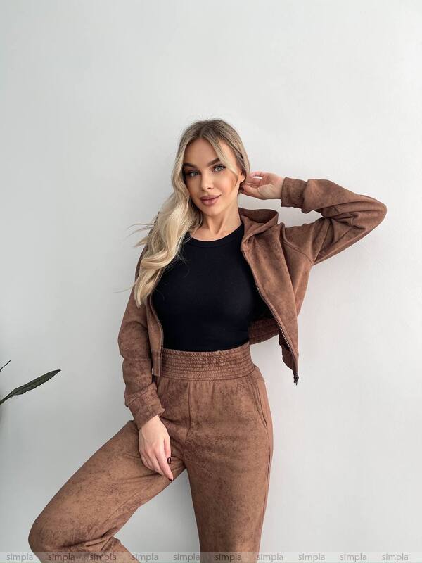 Woman wearing a brown outfit with a black top against a white background