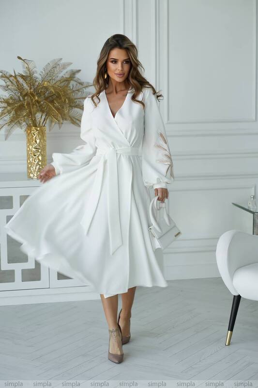 Woman wearing a white dress in a stylish room with decor elements.